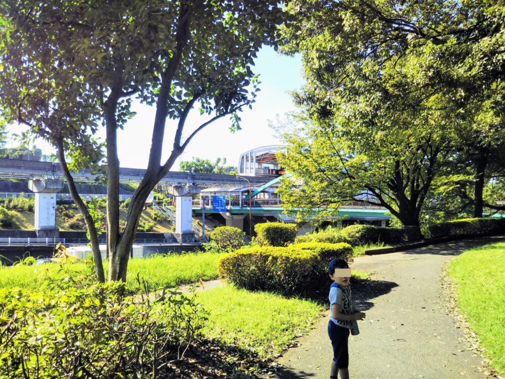 多摩モノレールが見える大塚東公園を歩く子供