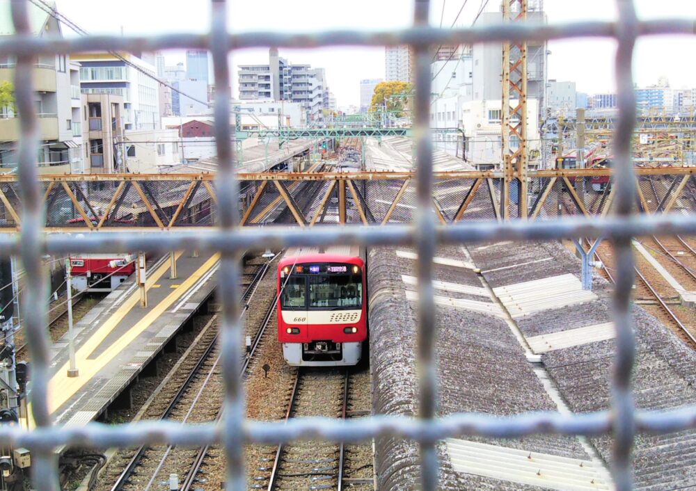 跨線橋から見える神奈川新町駅ホームに停車中の電車