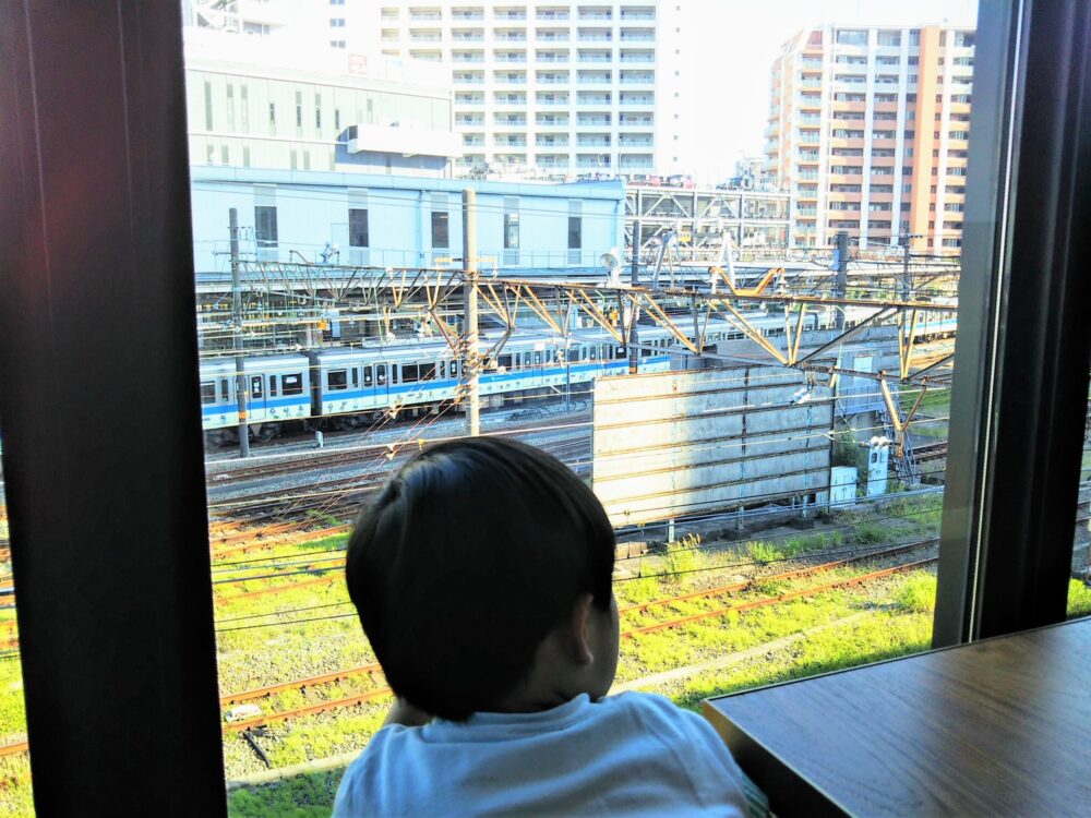 ロマンスカーミュージアムのカフェ店内（ソファ席から見える海老名駅と電車