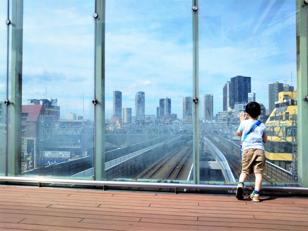 東急線の元住吉駅にある屋上庭園で電車を眺める子供