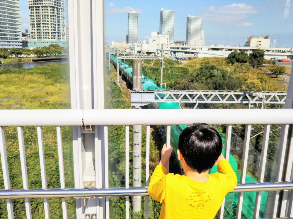 高島水際線公園｜公園内の線路に架かる歩道橋（跨線橋）から見えるタンク車と子供