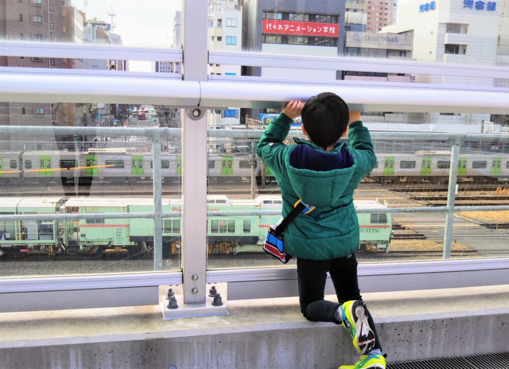 ダイヤゲート池袋｜ダイヤデッキから見えるJR線の電車と電車を見る子供