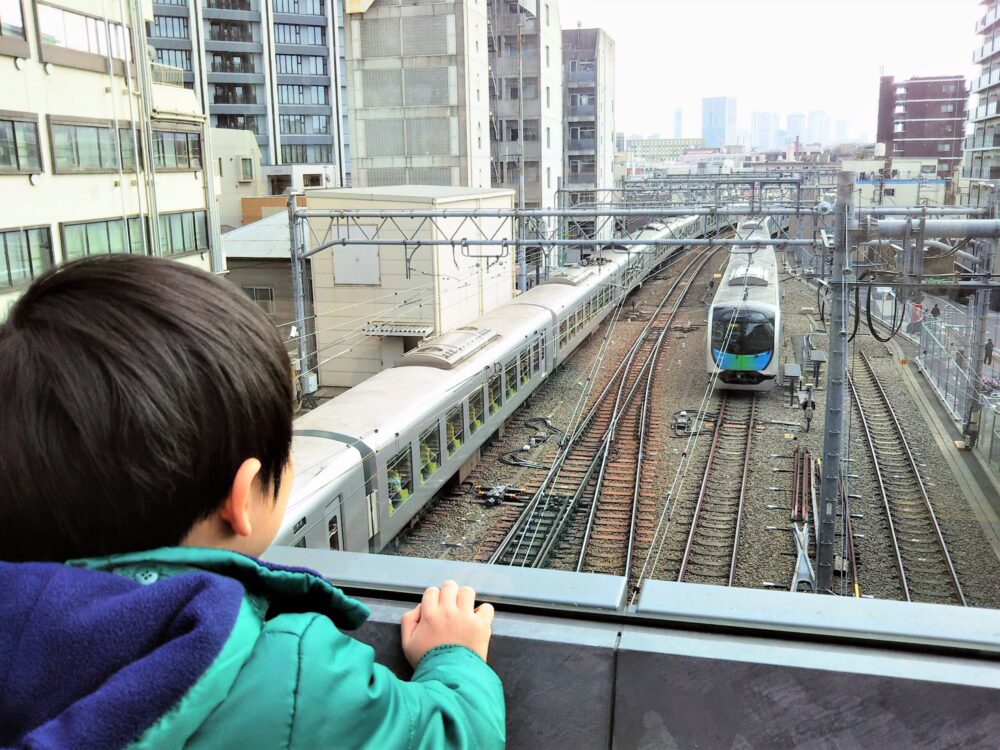 ダイヤゲート池袋｜ダイヤデッキから見える西武線の電車（ラビューと40000系）と電車を見る子供