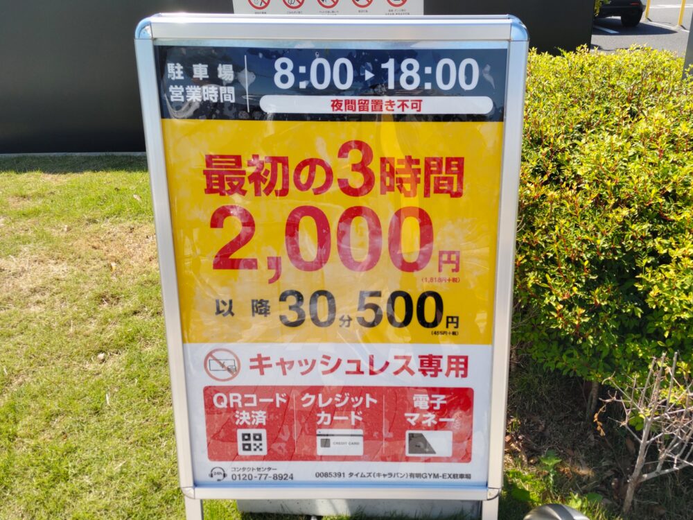 有明ジメックス臨時駐車場の営業案内板。営業時間は8:00〜18:00、最初の3時間2,000円、以降30分500円と記載。2026年5月の「プラレール博」参加時に撮影。